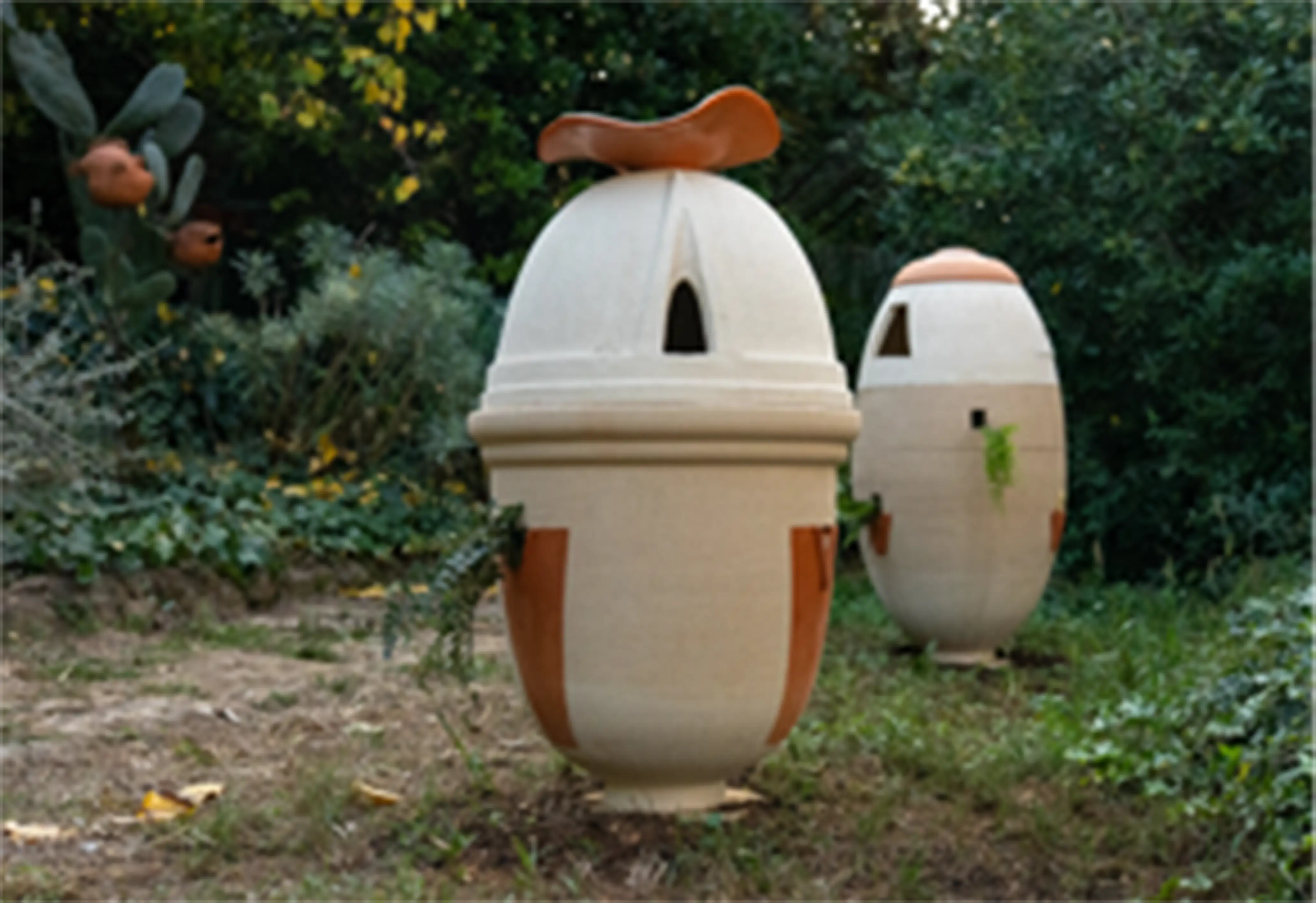 Mediatrix III terracotta jar, side view in a landscaped garden